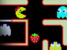 Screenshot of a pacman game maze, with Ms. Pacman, three ghosts and a strawberry.